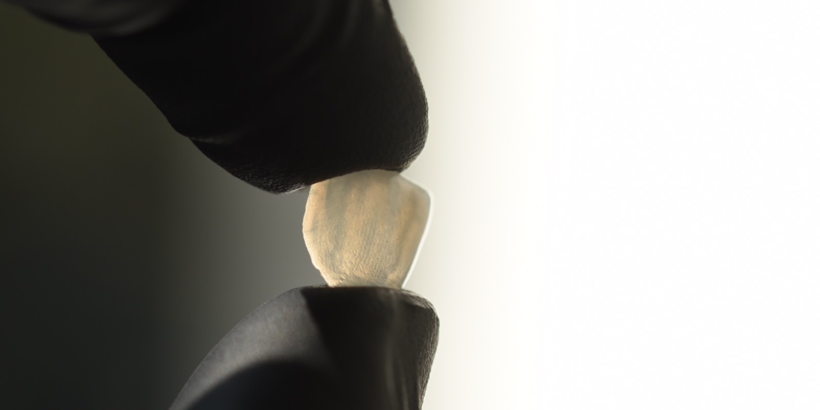 Carilla de cerámica de espesor mínimo sostenida entre los dedos