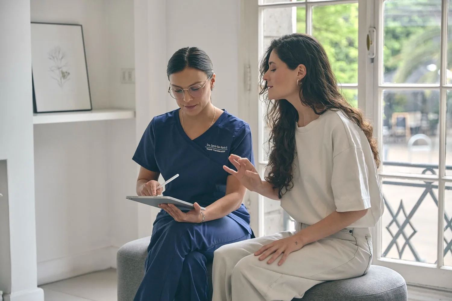 La Dra. Camila San Martín, periodoncista, revisa el diagnóstico en una tablet junto a la paciente